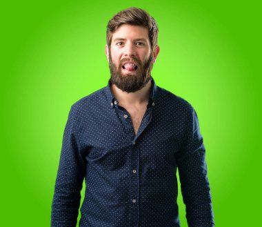 Yeşil arka plan üzerinde kamera işareti itaatsizlik, protesto ve saygısızlık dilini dışarı yapışmasını büyük sakallı genç hipster adam