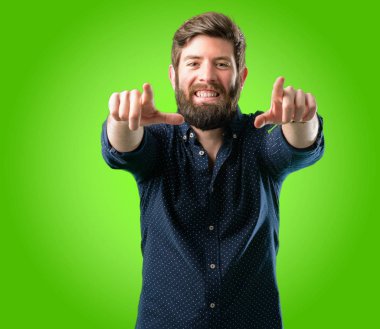 Parmak ile açık yeşil arka plan üzerinde işaret eden büyük sakallı genç hipster adam