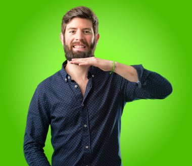 Bir şey boyutu kavram yeşil arka plan üzerinde tutan büyük sakallı genç hipster adam