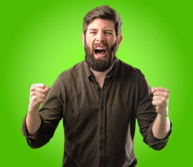 Büyük başarı, güç, enerji ve olumlu duygular ifade büyük sakal mutlu ve heyecanlı kutluyor zafer genç hipster adam. Yeni iş neşeli yeşil arka plan üzerinde kutluyor