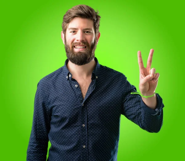 Молодой Хипстер Большой Бородой Поднимает Пальцы Номер Два Зеленом Фоне — стоковое фото