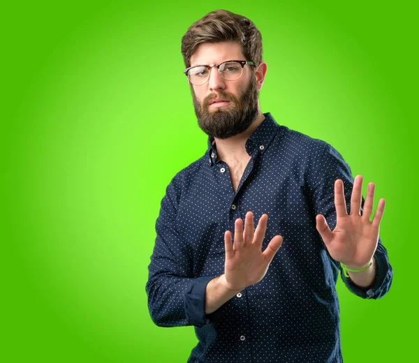 Hayır, güvenlik, savunma veya kısıtlama, belki üzerinde yeşil arka plana iterek ifade büyük sakallı genç hipster adam kötü tutum dur işareti el ile yapma ile rahatsız
