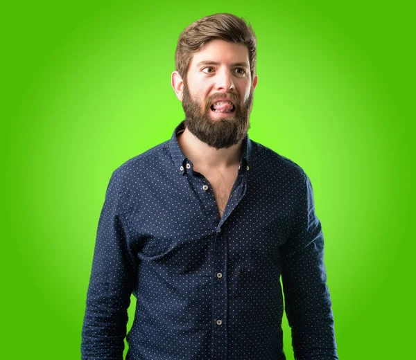 Yeşil arka plan üzerinde kamera işareti itaatsizlik, protesto ve saygısızlık dilini dışarı yapışmasını büyük sakallı genç hipster adam