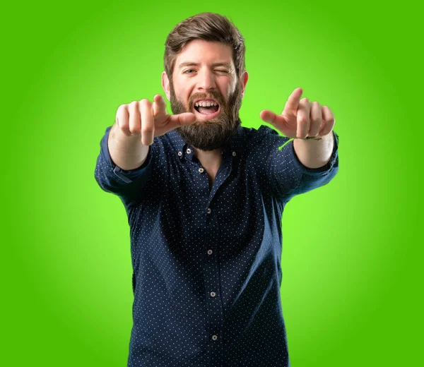 Parmak ile açık yeşil arka plan üzerinde işaret eden büyük sakallı genç hipster adam