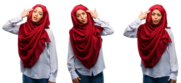 不幸なヒジャーブを身に着けているアラブの女性は自殺ジェスチャーを作るすべての疲れています 白い背景で銃を模倣する彼の手との撮影動揺分離 — ストック写真