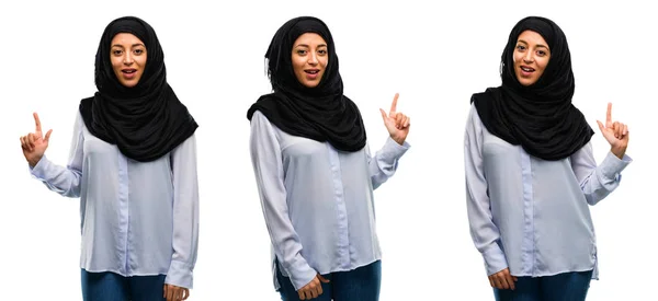 ホワイト バック グラウンドを分離した指でアウェイ側を指してヒジャーブを身に着けているアラブの女性 — ストック写真