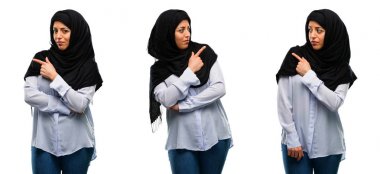 Uzak yan beyaz arka plan üzerinde izole parmak ile işaret hijab giyen Arap kadın