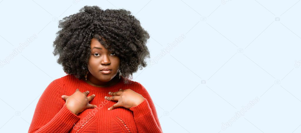 Beautiful african woman happy and surprised cheering expressing wow gesture, blue background