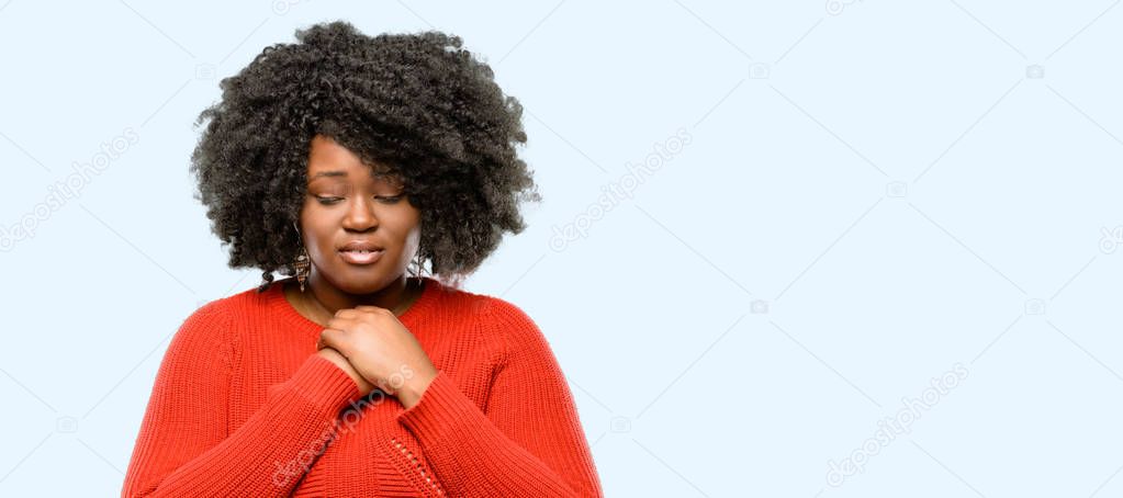 Beautiful african woman crying depressed full of sadness expressing sad emotion, blue background