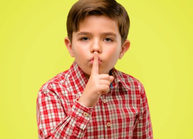 Yakışıklı yürümeye başlayan çocuk dilinde, işaret parmağı ile yeşil gözlü sormak sessiz olmalısın. Sessizlik ve gizli kavram sarı arka plan üzerinde
