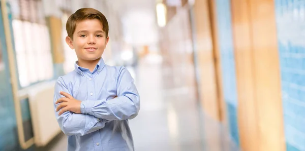 自信を持って 大きな自然に満足して組んだ腕緑目のハンサムな幼児子供は学校の廊下で笑って笑顔します — ストック写真