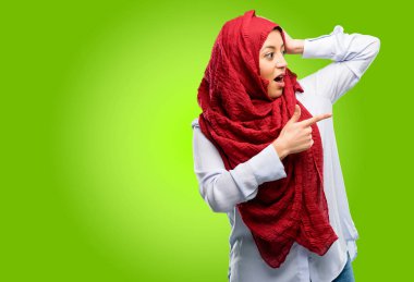 Uzak yan parmağıyla işaret hijab giyen genç Arap kadın