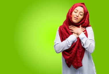 Sevgi ve sağlık kavramı ifade kalbinde, elleriyle hijab giyen genç Arap kadın