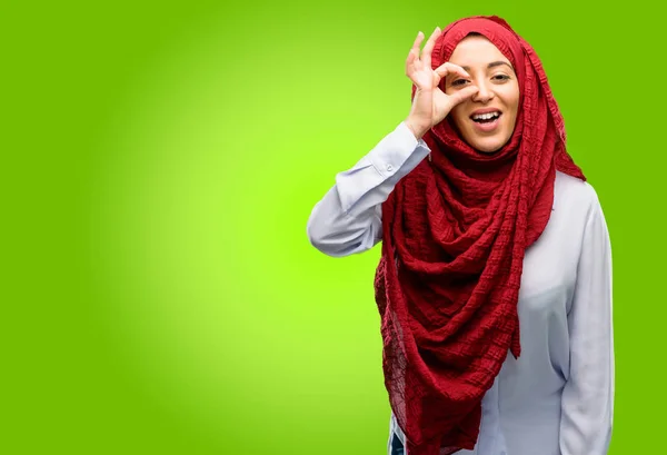 若いアラブ女性 のジェスチャーの彼女の指の間からカメラ目線ヒジャーブを身に着けています 双眼鏡 美しい目と笑顔 — ストック写真
