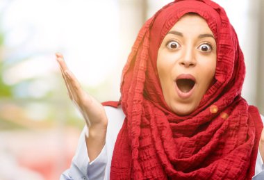 Mutlu ve ifade wow jest tezahürat hijab giyen genç Arap kadın