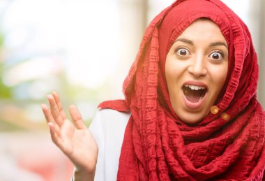 Mutlu ve ifade wow jest tezahürat hijab giyen genç Arap kadın