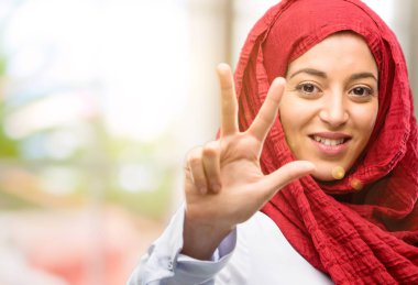 Onun parmak yükselterek hijab giyen genç Arap kadın olduğunu üç numaralı