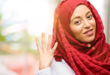 Onun parmak yükselterek hijab giyen genç Arap kadın olduğunu dört sayısı