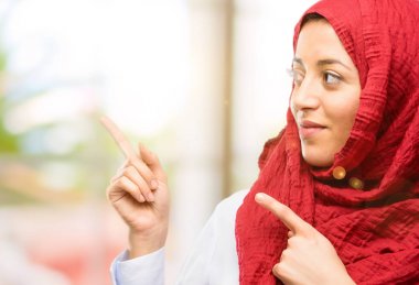 Uzak yan parmak ile işaret hijab giyen genç Arap kadın