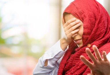 Stresli ve utangaç baş, yorgun ve sinirli el tutmak hijab giyen genç Arap kadın