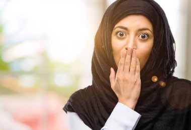 Hijab giyen genç Arap kadın şok ağzına kapakları, sessizlik ve hata kavramlar, korkmuş ifade utangaç, görünüyor
