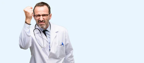 Doctor senior man, medical professional irritated and angry expressing negative emotion, annoyed with someone isolated over blue background