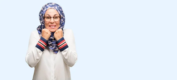 恐怖と緊張のヒジャーブを着て中年イスラム アラブ女性不安とパニックの身振りを表現する分離の青い背景を圧倒しました — ストック写真
