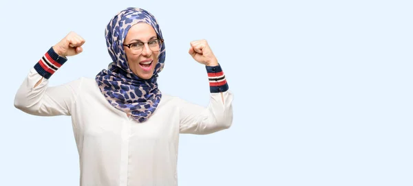 中世纪穆斯林阿拉伯妇女戴头巾高兴和兴奋庆祝胜利表达了巨大的成功 能量和积极的情绪 庆祝新工作快乐孤立的蓝色背景 — 图库照片