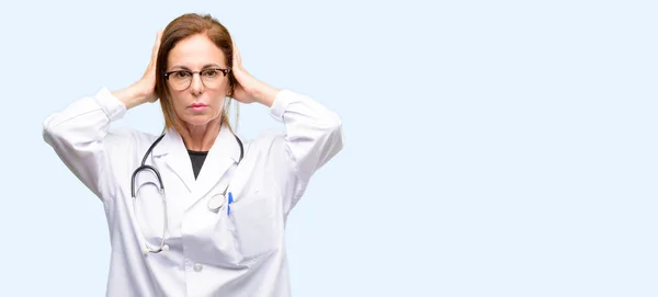 医師女性 迷惑な騒音を無視しての耳をカバーする医療専門家の音が聞こえないように耳をプラグします 騒々しい音楽は問題です 孤立した青色の背景 — ストック写真