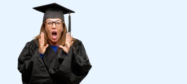 Kıdemli yüksek lisans öğrencisi kadın stresli tutmak ellerini kafasına, izole mavi arka plan bağırarak panikle dehşete