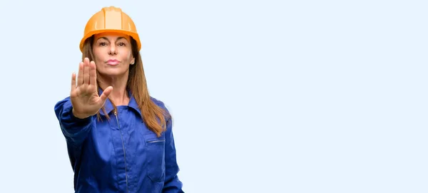 工程施工工人妇女对不良态度感到恼火 用手停止手势 表示安全 防守或限制 可能推孤立的蓝色背景 — 图库照片