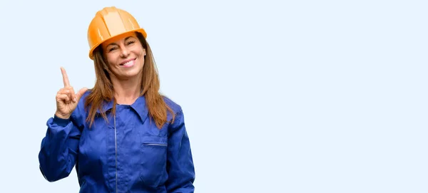 Ingenieur Bauarbeiter Frau Zeigt Seite Mit Finger Isoliert Blauen Hintergrund — Stockfoto
