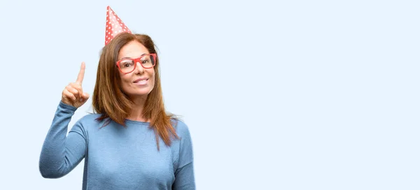中年の女性が幸せと分離の青い背景を指して表現するすごいジェスチャーを応援して驚いたの誕生日を祝う — ストック写真