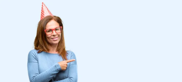 Mulher Meia Idade Celebra Aniversário Apontando Para Lado Com Dedo — Fotografia de Stock