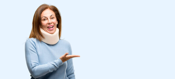 Injured woman wearing neck brace collar holding something in empty hand isolated blue background