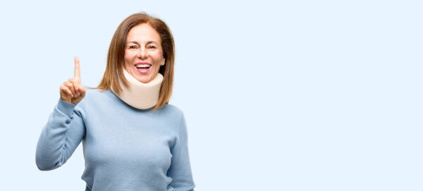 Injured woman wearing neck brace collar pointing away side with finger isolated blue background