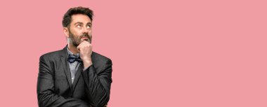 Orta yaş adam, sakal ve papyon düşünme ve şüphe ve merak ifade arıyorum