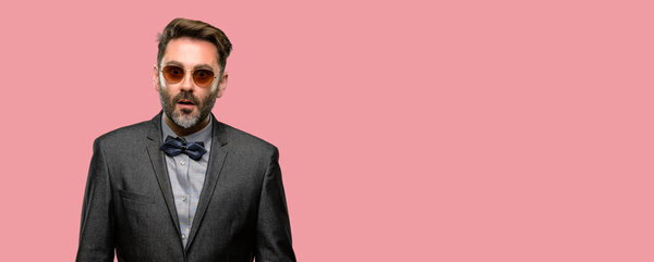 Мужчина средних лет, с бородой и галстуком-бабочкой, напуганный от шока, выражающий панику и страх
