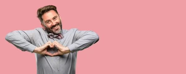 心臓形状表現健康的な結婚のシンボルで手で好色な中年男性 ひげと蝶ネクタイの幸せ — ストック写真