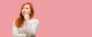 Güzel genç Kızıl saçlı kadın şüphe ifade, şaşırtmak ve kavramı, belirsiz gelecek merak ediyorum