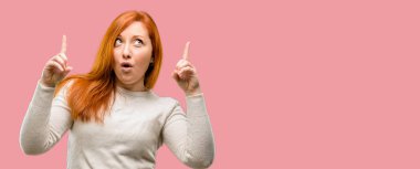 Güzel genç Kızıl saçlı kadın mutlu ve yukarı dönük ifade wow jest tezahürat