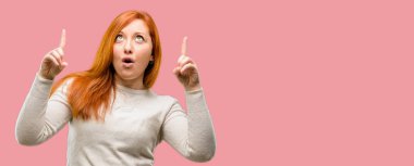 Güzel genç Kızıl saçlı kadın mutlu ve yukarı dönük ifade wow jest tezahürat