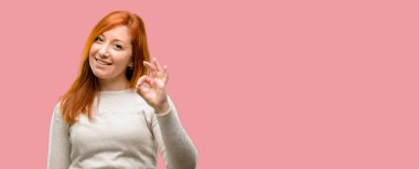 Güzel genç Kızıl saçlı kadının el ile ok işareti yapması onaylama hareketi