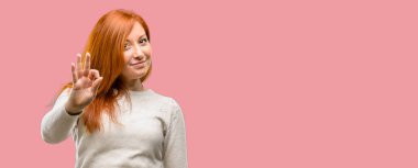 Güzel genç Kızıl saçlı kadının el ile ok işareti yapması onaylama hareketi