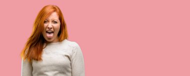 Kamera işareti itaatsizlik, protesto ve saygısızlık dilini dışarı yapışmasını güzel genç Kızıl saçlı kadın