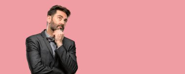 Orta yaş adam, sakal ve papyon düşünme ve şüphe ve merak ifade arıyorum