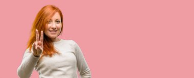 Parmak, iki numaralı yükselterek güzel genç Kızıl saçlı kadın