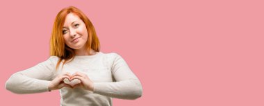 Güzel genç Kızıl saçlı kadın mutlu gösteren aşk elinde kalp şekli sağlıklı ifade ve evlilik sembolü ile