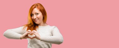 Güzel genç Kızıl saçlı kadın mutlu gösteren aşk elinde kalp şekli sağlıklı ifade ve evlilik sembolü ile