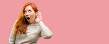 İletişim kavramı ve dedikodu ifade ilginç haberleri dinlemek için kulak yakınındaki el tutan güzel genç Kızıl saçlı kadın